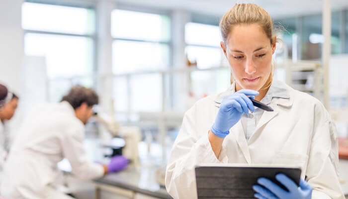 Female lab technician analyzing test results on a tablet computer