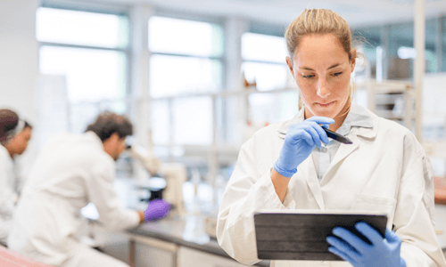 Female lab technician analyzing test results on a tablet computer